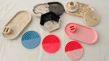 Colorful trays and coasters on a white surface.