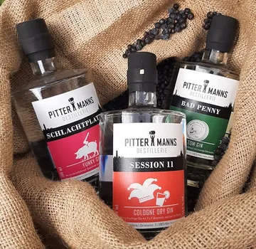 Three gin bottles on burlap sack.