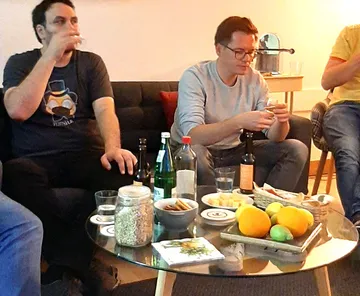 People sitting, drinking in a living room.