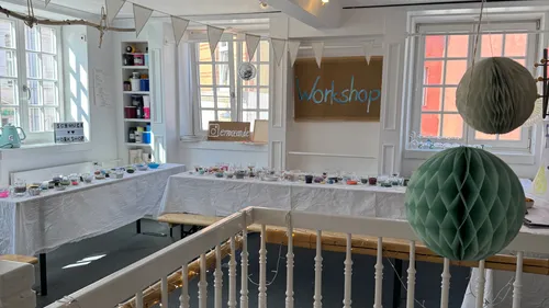 Dekorierter Workshop mit Tischen und Zubehör.