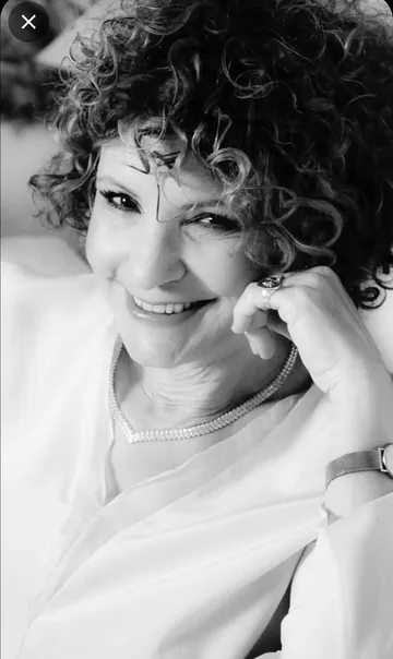 Smiling woman with curly hair indoors.