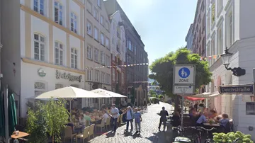 People dining outside on a cobblestone street.