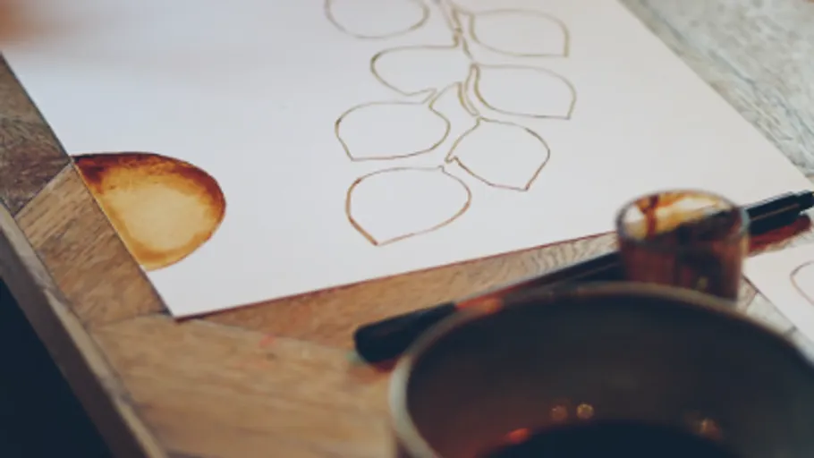 Paper with leaf sketches and coffee stain.