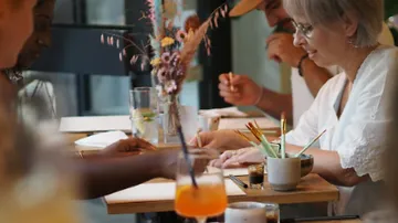 People drawing together at a wooden table.