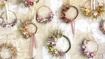 Floral wreaths hanging on textured wall.