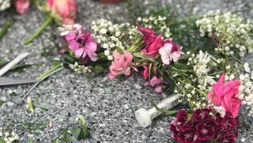 Floral arrangement with scissors on a stone surface.