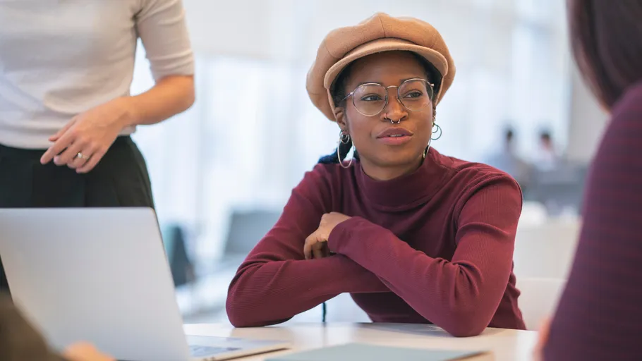 Person in hat talking at a table.