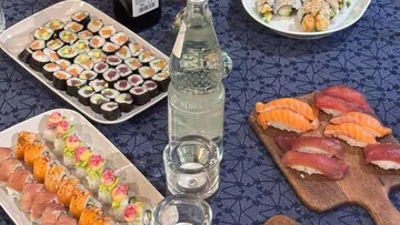 Various sushi platters on a patterned table.