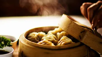 Steamed dumplings in a bamboo steamer.