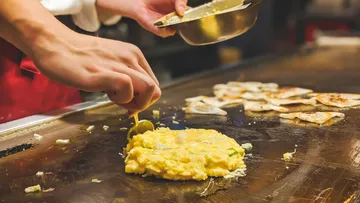 Chef making omelette on a griddle.