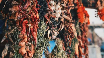 Dried herbs and peppers hanging in market.