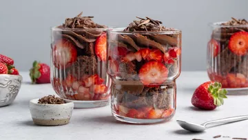 Glasses filled with chocolate mousse and strawberries.
