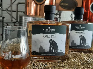 Whiskyflaschen stehen auf einem Tisch in einer Destillerie.