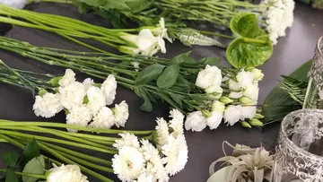 White flowers arranged on a dark table.