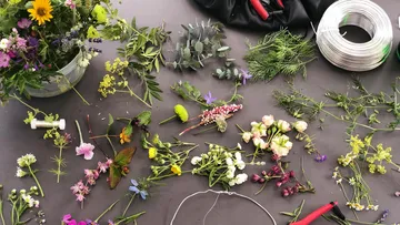 Flowers and tools arranged on a gray table.