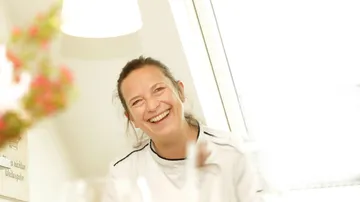 Lächelnde Frau in einem hellen Raum.