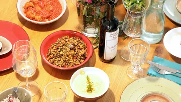 Dinner table with various dishes and wine.
