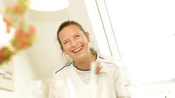Smiling person indoors in bright room.