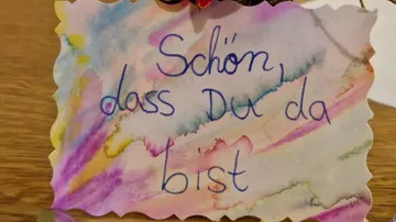Colorful card with handwritten German text.