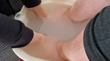 Feet soaking in a water basin.