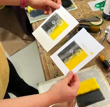 Hände halten Sonnenblumendruck auf Kunsttisch.