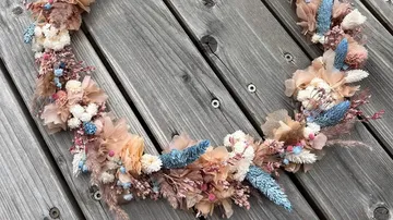 Dried flower wreath on wooden surface.
