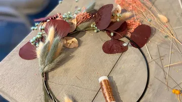 Blumenschmuck wird auf einem Tisch gebastelt.