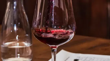 Rotwein in Glas auf Tisch.