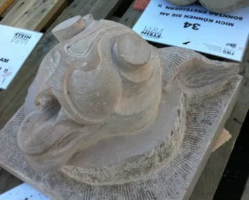 Steindrachen-Skulptur auf einem Holztisch.
