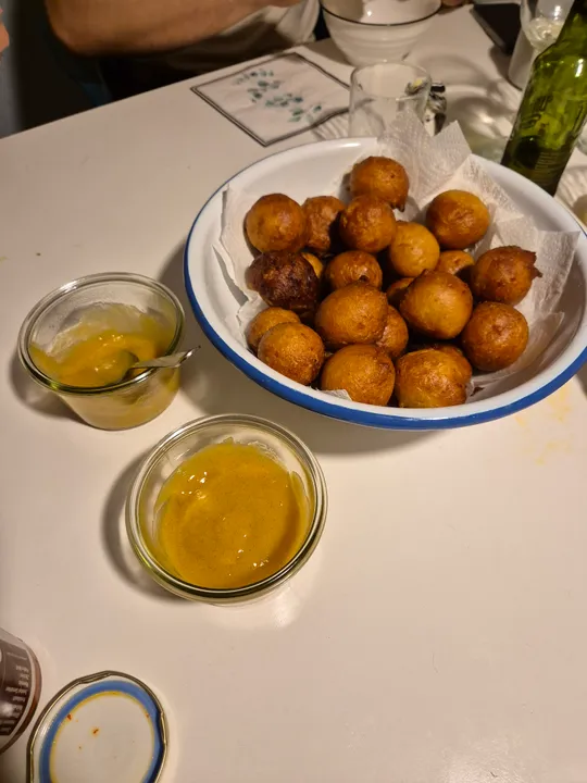Fried balls and sauces on a table.