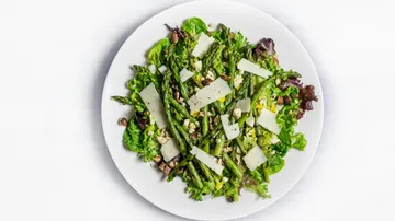 Salat mit Spargel, Käse, Nüssen auf Teller.