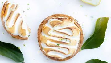 Lemon meringue tarts with green leaves.