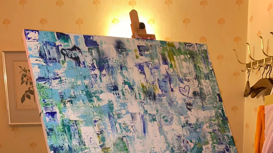 Abstraktes Gemälde auf Staffelei in einer Raumecke.