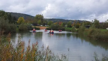 People kayaking on a calm river.