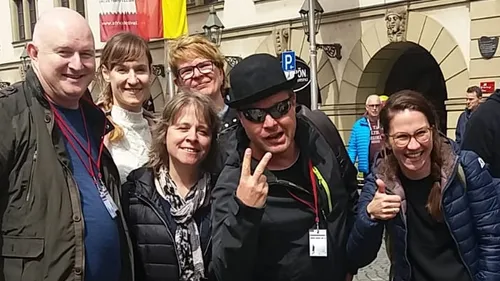 Gruppe von Menschen lächelt vor historischem Gebäude.