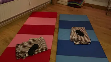 Zwei Matten mit Decken und Masken auf Boden.