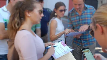 People studying papers in an outdoor group.