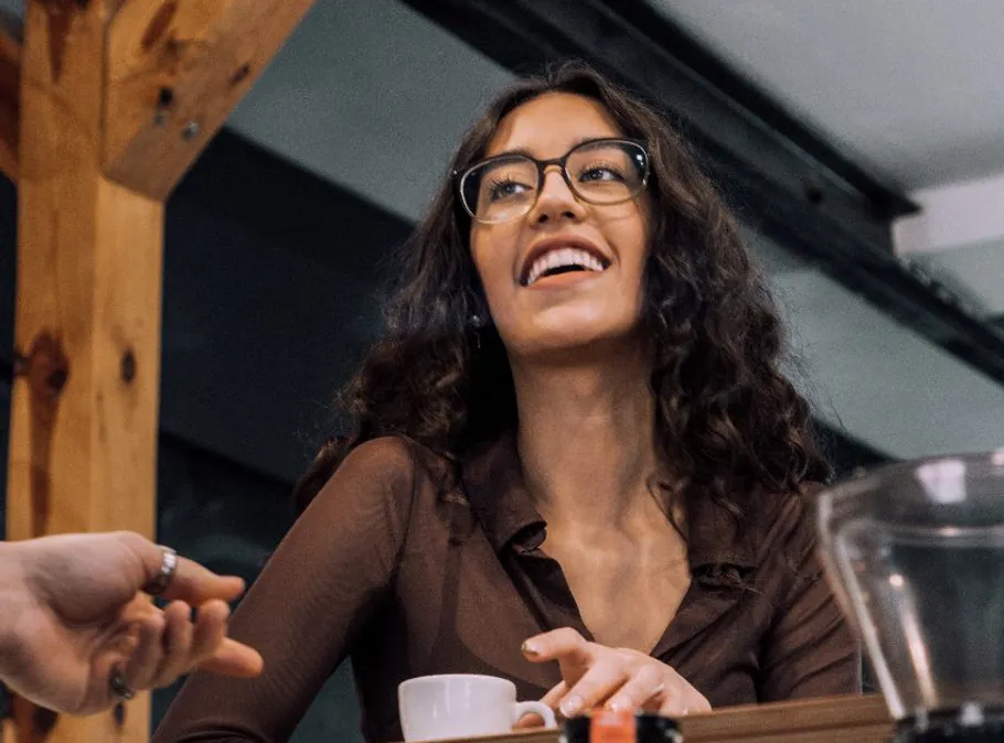 Smiling woman with glasses in a café.