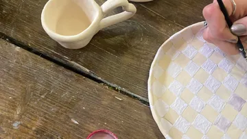 Hand bemalt Keramikteller auf Holztisch.