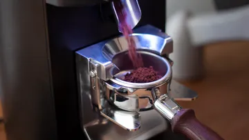 Portafilter erhält Kaffeemehl aus Mühle.