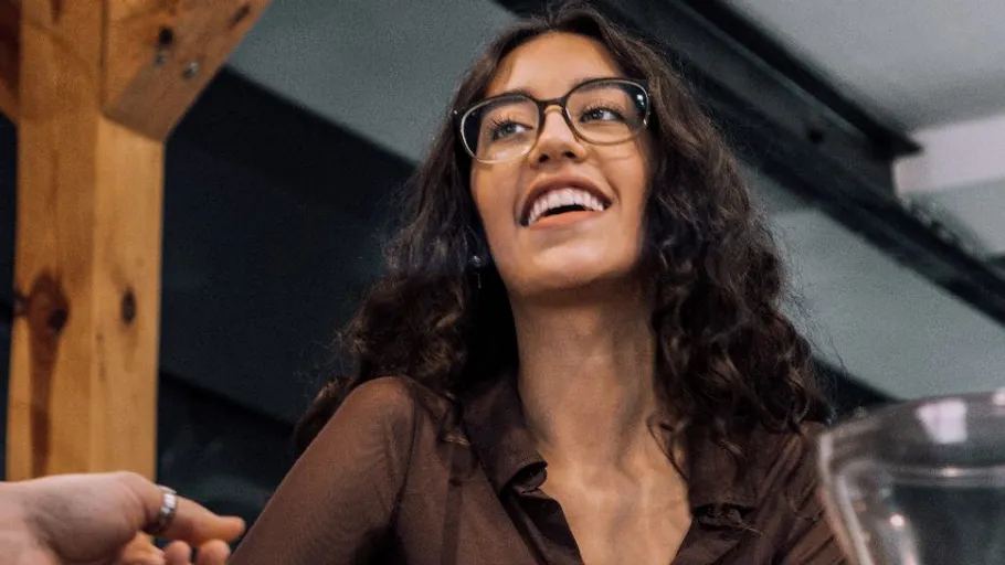 Lächelnde Frau mit Brille im Café.