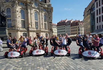 Group riding circular bike in European square.