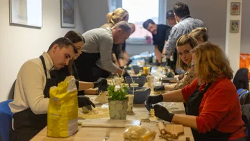 Leute stellen Knödel an einem Workshop-Tisch her.