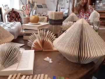 Books are folded into creative shapes on a table.