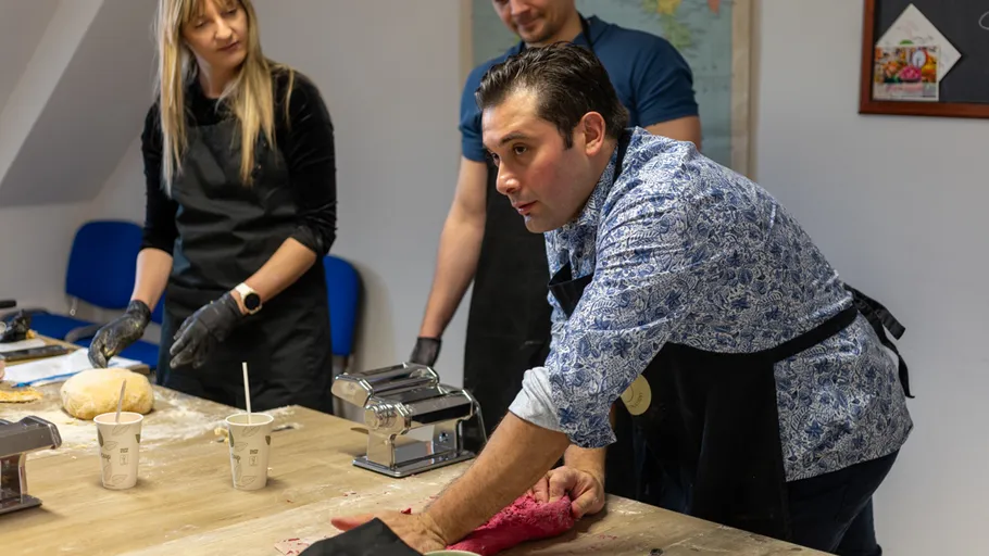 People making pasta dough in a kitchen.