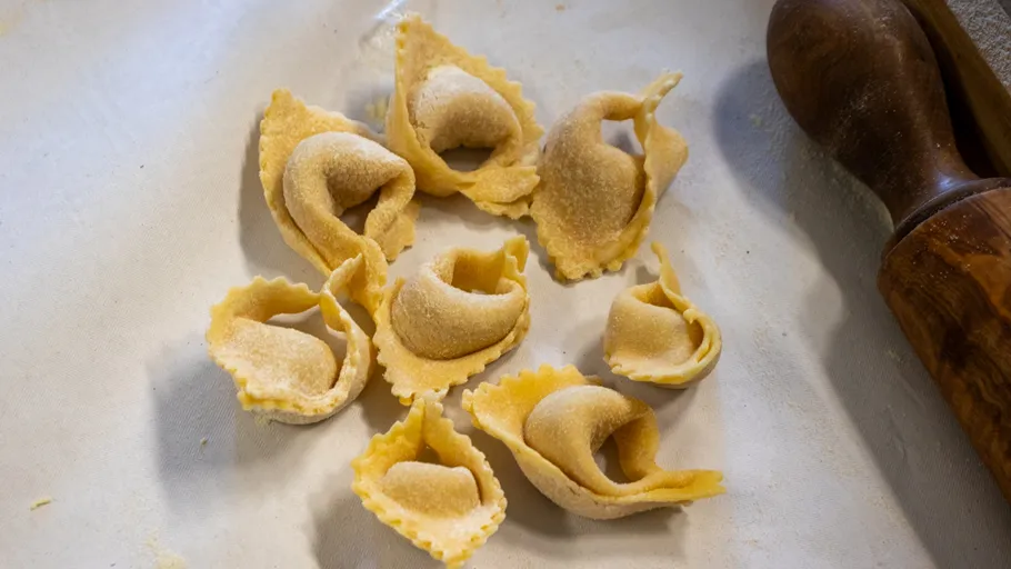 Fresh tortellini on a white surface.