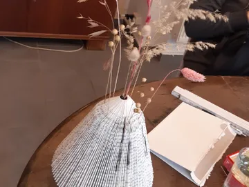 Vase made of folded sides decorated with dried flowers.