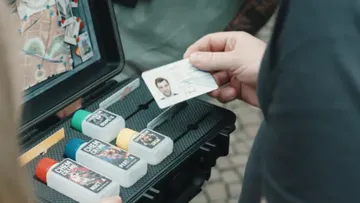 Person holding ID next to chemical kit.