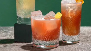 Drei Cocktails mit Eis in strukturierten Gläsern.