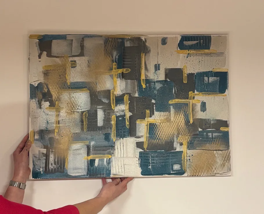 Abstract painting held up against a wall.